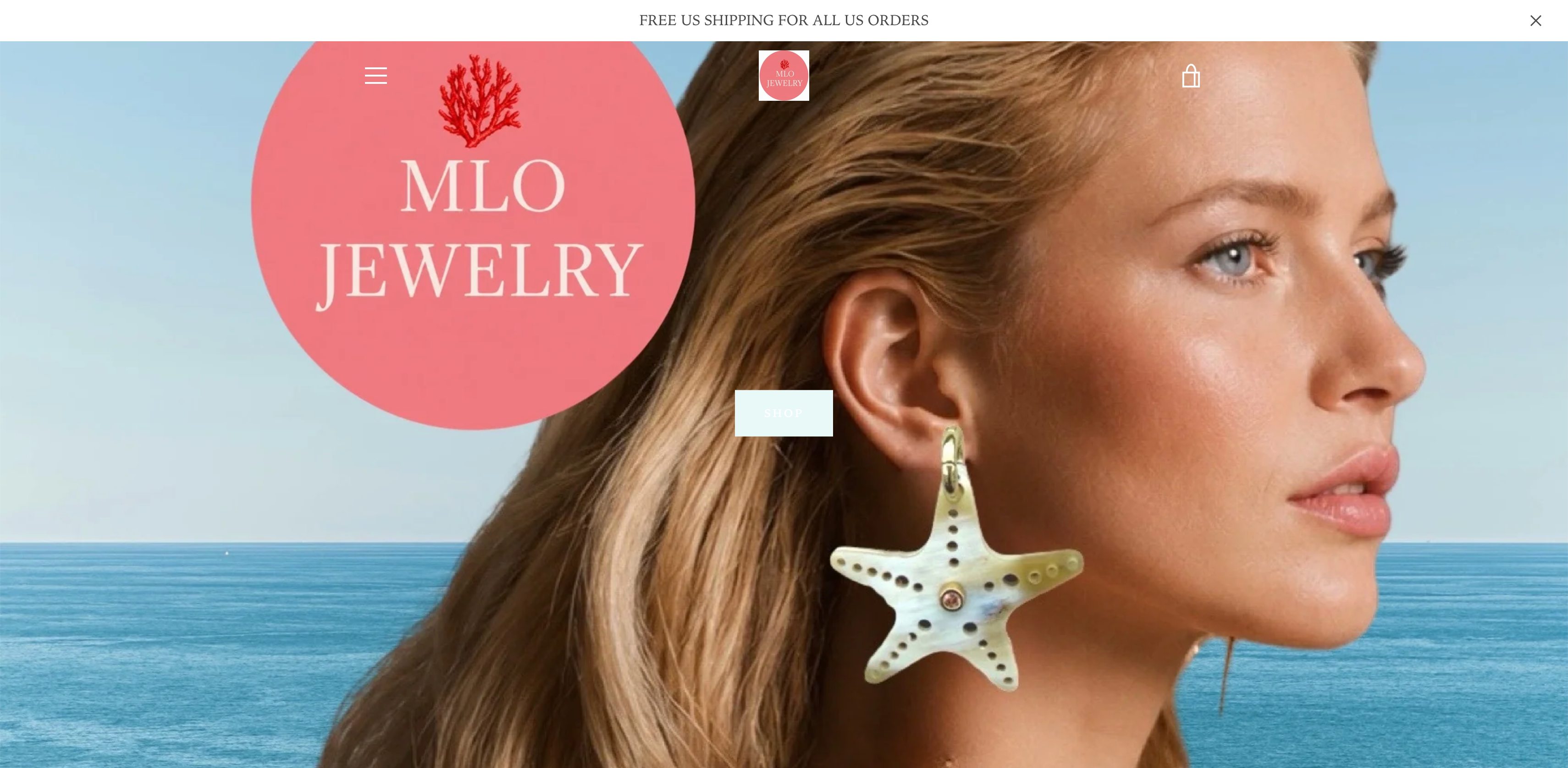 Original homepage hero: a giant pink MLO logo circle pasted over a model wearing a starfish earring